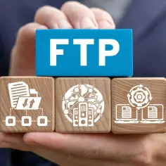 Dłonie trzymają klocki symbolizujące transfer plików przez ftp port: dane, serwery, synchronizacja.